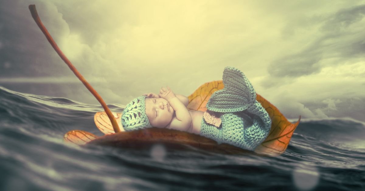 Merman names - A baby with a blue crochet mermaid tail on the sea