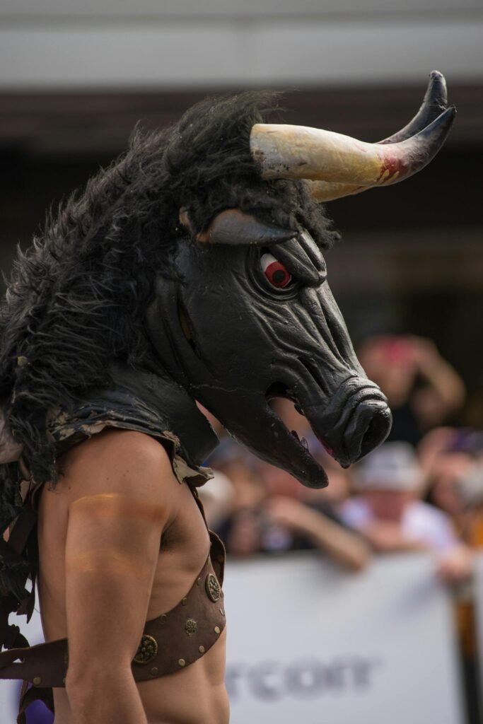 A performer wearing a bull mask participates in an exciting outdoor festival.